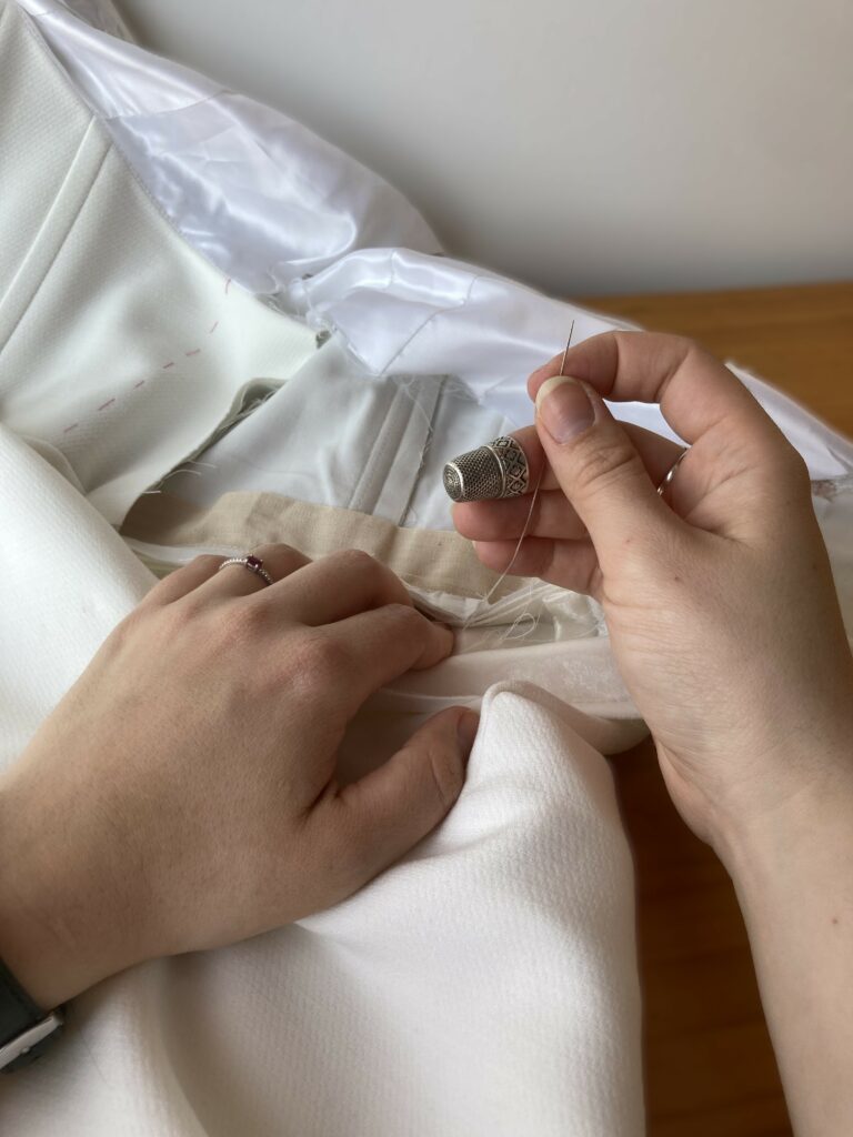 Couturière cousant une robe de mariée